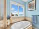 Relaxing bathroom with soaking tub, tile shower, and water views at 110 Driftwood Ln, Largo, FL 33770