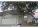 Front view of a single-story house with a two-car garage and mature landscaping at 1922 Echo Pond Pl, Wesley Chapel, FL 33543