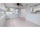 Sunroom with tile flooring, ceiling fan and access to kitchen at 235 Se Madison N Cir, St Petersburg, FL 33703