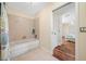 Bathroom with a soaking tub and view to the primary bedroom at 2418 Falcon Ln, Palm Harbor, FL 34683