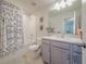 Clean bathroom with shower, tub, vanity, and patterned curtain at 28818 Orange Berry Dr, Wesley Chapel, FL 33543