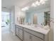 Bright bathroom boasts double vanity, large mirror, and view of bedroom at 28818 Orange Berry Dr, Wesley Chapel, FL 33543