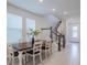 Dining area with farmhouse table, white chairs, and natural light at 28818 Orange Berry Dr, Wesley Chapel, FL 33543