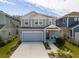 Two-story house with light blue siding, two-car garage, and landscaping at 28818 Orange Berry Dr, Wesley Chapel, FL 33543