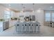 Modern kitchen with white cabinets, island with seating, and stainless steel appliances at 28818 Orange Berry Dr, Wesley Chapel, FL 33543