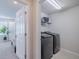 Bright laundry room with washer, dryer, and shelving at 28818 Orange Berry Dr, Wesley Chapel, FL 33543