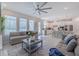 Open living space with grey sofas and kitchen view at 28818 Orange Berry Dr, Wesley Chapel, FL 33543