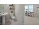 Clean powder room with floating shelves and view to dining area at 28818 Orange Berry Dr, Wesley Chapel, FL 33543