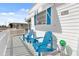 Quaint front porch with blue adirondack chairs and white picket fence at 37309 Beverly Ave, Zephyrhills, FL 33542