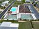 Aerial view showing pool, shuffleboard courts, and clubhouse at 37622 New Horizons Blvd, Zephyrhills, FL 33541