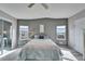 Bedroom with ceiling fan, mirrored closet and grey accent wall at 37622 New Horizons Blvd, Zephyrhills, FL 33541