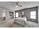 Bright bedroom with ceiling fan, mirrored closet, and two windows at 37622 New Horizons Blvd, Zephyrhills, FL 33541