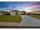 Sunset view of a manufactured home with carport and landscaped lawn at 37622 New Horizons Blvd, Zephyrhills, FL 33541