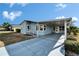 Light blue manufactured home with carport and landscaping at 37622 New Horizons Blvd, Zephyrhills, FL 33541