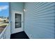 Front door entrance with white railing and storm door at 37622 New Horizons Blvd, Zephyrhills, FL 33541