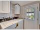 Clean laundry room features a washer, dryer, and storage cabinets at 37622 New Horizons Blvd, Zephyrhills, FL 33541