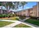 Charming condo building with stairs and sidewalk surrounded by well maintained lawns and trees at 4725 Christa Ct # 331, Tampa, FL 33614