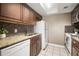 Galley kitchen showcasing stone counters, mosaic backsplash, white appliances, and wood cabinets at 4725 Christa Ct # 331, Tampa, FL 33614