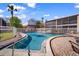 Community pool surrounded by white fence, brick pavers, and lounge chairs, offering a relaxing outdoor space at 4725 Christa Ct # 331, Tampa, FL 33614