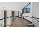 Light-filled hallway with glass railings and hardwood floors at 730 W Alda Ne Way, St Petersburg, FL 33704