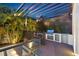 Outdoor kitchen with grill and bar under a pergola at dusk at 730 W Alda Ne Way, St Petersburg, FL 33704