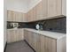 Modern wet bar with light wood cabinets, dark chevron backsplash, and white countertops at 730 W Alda Ne Way, St Petersburg, FL 33704