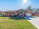 Attractive orange house with a green roof and nicely landscaped lawn at 9444 Monica Dr, Seminole, FL 33777