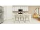 White kitchen features a breakfast bar with three stools at 10264 Alder Green Dr, Riverview, FL 33578