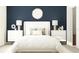 Bedroom with white bed, nightstands, and a dark blue accent wall at 11915 Blue Diamond Trl, Parrish, FL 34219