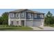 Two-story home with gray siding, stone accents, and a three-car garage at 11915 Blue Diamond Trl, Parrish, FL 34219