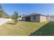 Back exterior view of a tan house with a fenced backyard at 12312 Bay Estuary Bnd, Riverview, FL 33579