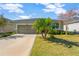 Single-story house with a green facade, attached garage, and palm trees in the front yard at 13122 Satin Lily Dr, Riverview, FL 33579