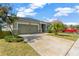House exterior showcasing a green color scheme, landscaping, and a spacious driveway at 13122 Satin Lily Dr, Riverview, FL 33579