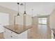 Open concept kitchen with island, looking toward living room and sliding doors at 13122 Satin Lily Dr, Riverview, FL 33579