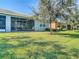 Spacious backyard with lush landscaping and screened patio at 15724 Aurora Lake Cir, Wimauma, FL 33598