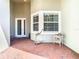 Front entry with a brick-paved patio, featuring a bay window and white door at 15724 Aurora Lake Cir, Wimauma, FL 33598