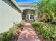 Brick walkway leading to the front entrance of a light green house at 15724 Aurora Lake Cir, Wimauma, FL 33598
