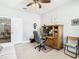 Home office with built-in desk, comfortable seating, and view to dining area at 15724 Aurora Lake Cir, Wimauma, FL 33598