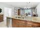 Island kitchen with granite countertops, double sink, and stainless steel dishwasher at 15724 Aurora Lake Cir, Wimauma, FL 33598
