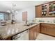 Kitchen island with granite countertop, stainless steel appliances and wooden cabinets at 15724 Aurora Lake Cir, Wimauma, FL 33598