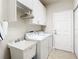 Laundry room with washer, dryer, utility sink, and ample storage at 15724 Aurora Lake Cir, Wimauma, FL 33598