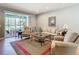 Bright living room with comfy seating, large windows, and access to a screened patio at 15724 Aurora Lake Cir, Wimauma, FL 33598