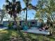 Backyard with a wooden deck, palm trees, and a partially visible house at 1599 Arizona Ne Ave, St Petersburg, FL 33703