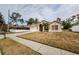 House exterior view showcasing a tan house with a garage and lawn at 1833 Hillcrest St, Tarpon Springs, FL 34689