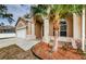 Landscaped front yard with palm tree and tile walkway at 1833 Hillcrest St, Tarpon Springs, FL 34689