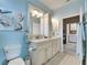 Double vanity bathroom with upgraded cabinetry and tile floors at 205 Silver Falls Dr, Apollo Beach, FL 33572