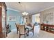 Formal dining room with a round table and four chairs, light tile floors, and a light blue wall at 205 Silver Falls Dr, Apollo Beach, FL 33572