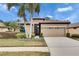 Tan one-story house with two palm trees, a two-car garage, and a landscaped yard at 205 Silver Falls Dr, Apollo Beach, FL 33572