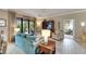 Cozy living room with teal sofa and light wood floors, looking toward a second living space at 205 Silver Falls Dr, Apollo Beach, FL 33572
