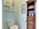 Small powder room with toilet, shelving, and wooden cabinet at 205 Silver Falls Dr, Apollo Beach, FL 33572